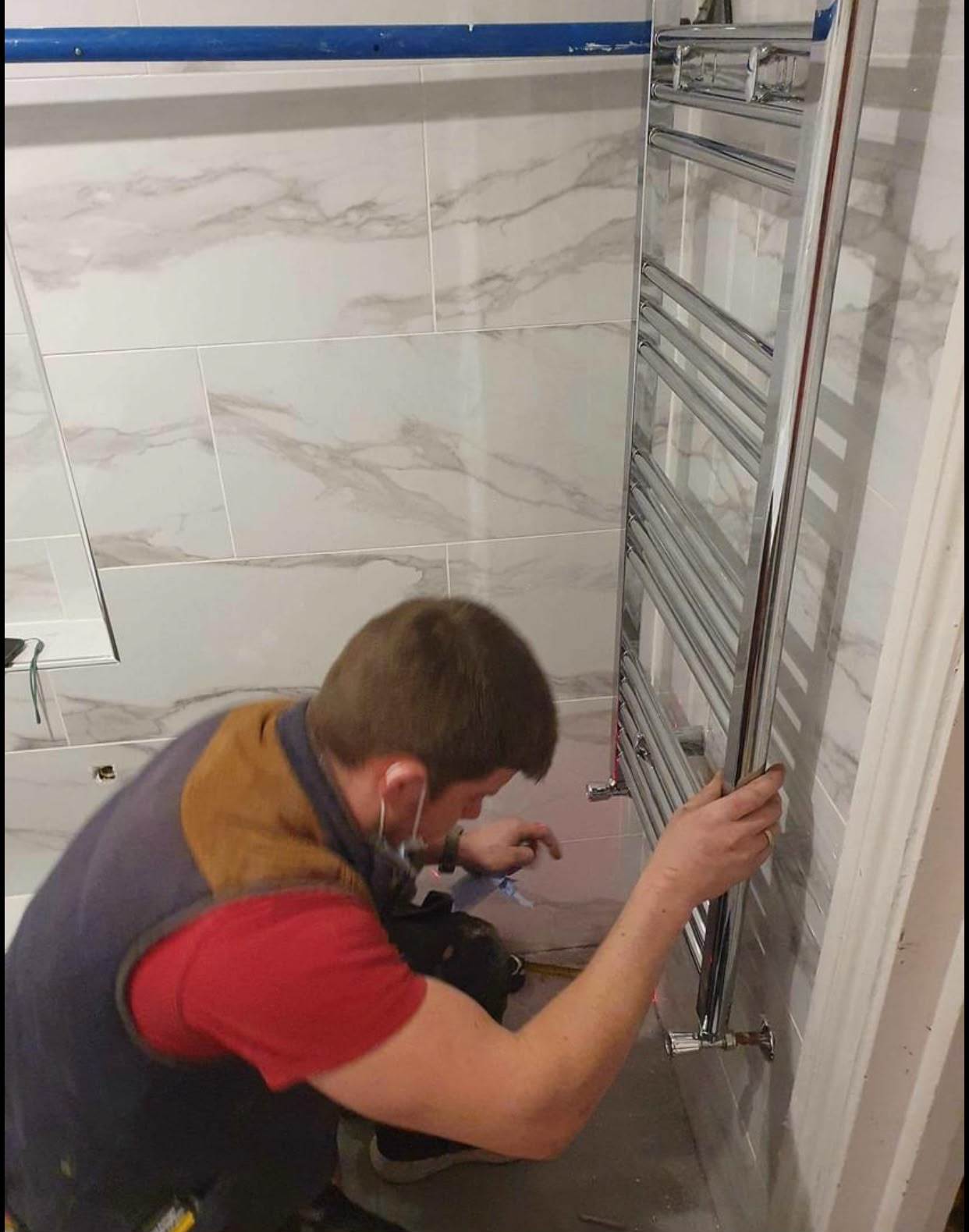 Heated towel radiator installed in a tiled bathroom
