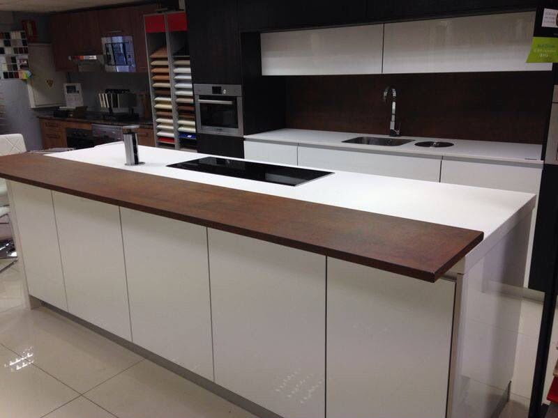 White gloss kitchen island with black glass hob and wood breakfast bar by Aaron Steven Construction
