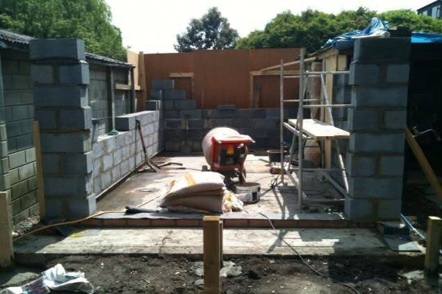 New blockwork garage walls being built on a fresh concrete slab