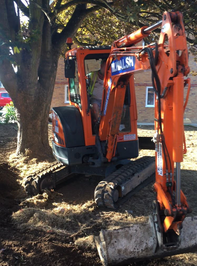 Mini excavator digging out a garden during landscaping works