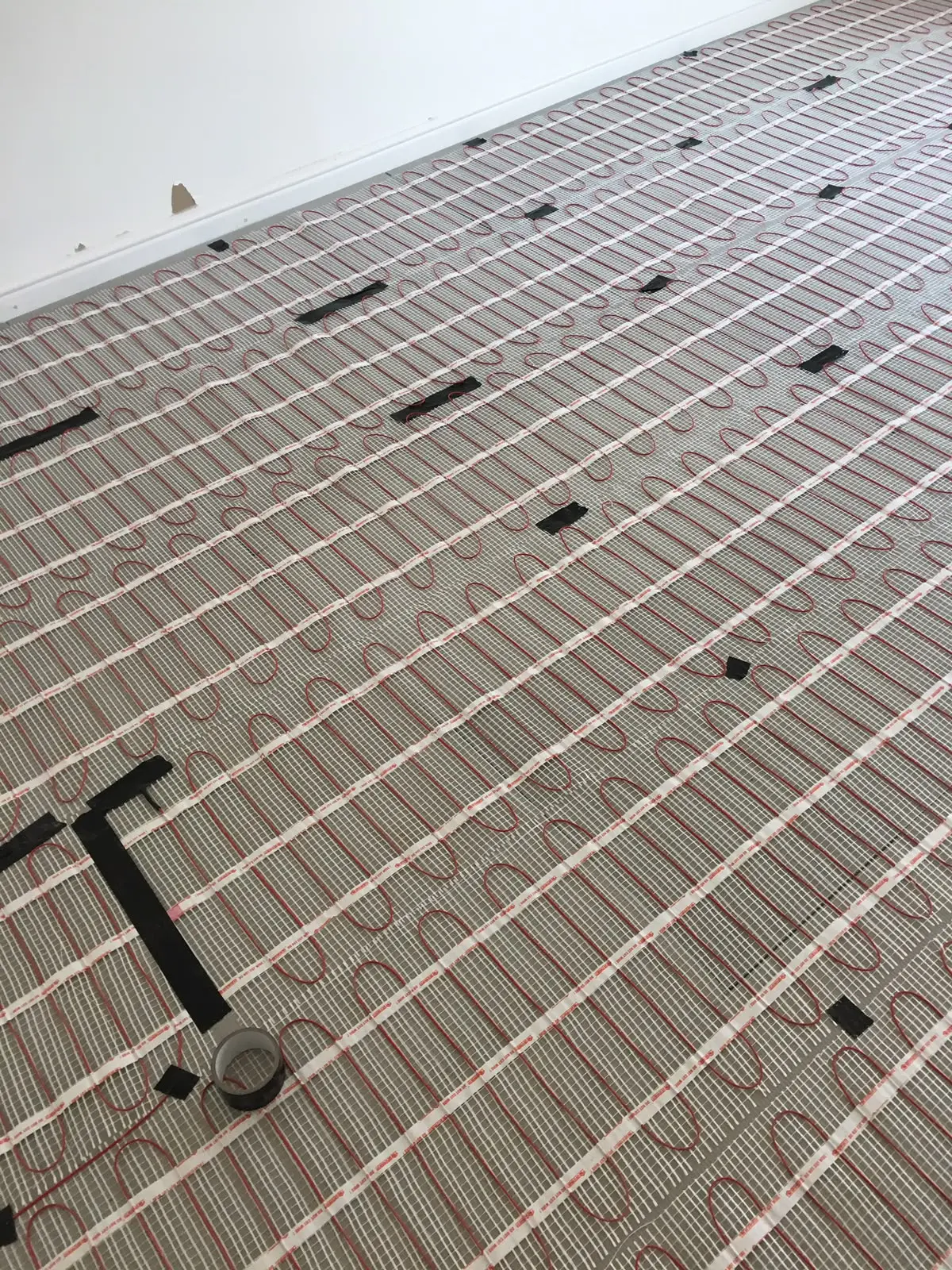 Electric underfloor heating cable matting laid over a prepared subfloor