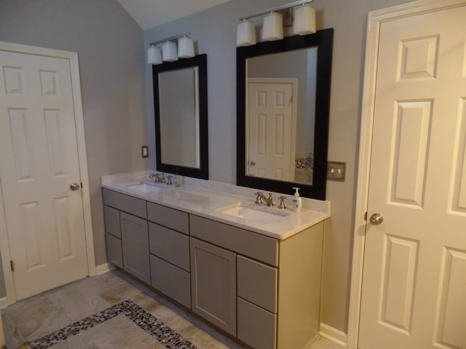 Grey twin-basin bathroom vanity with black-framed mirrors by Aaron Steven Construction